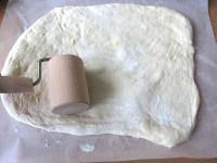 Tepsi méretű sütőpapíron a tészta egyik...